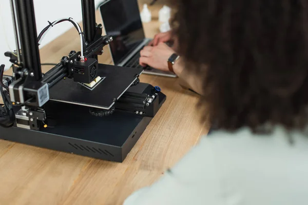Blick aus der Vogelperspektive auf junge Designer, die mit 3D-Drucker und Laptop im modernen Büro arbeiten — Stockfoto