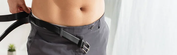 Cropped view of shirtless man wearing waist belt at home, banner — Stock Photo