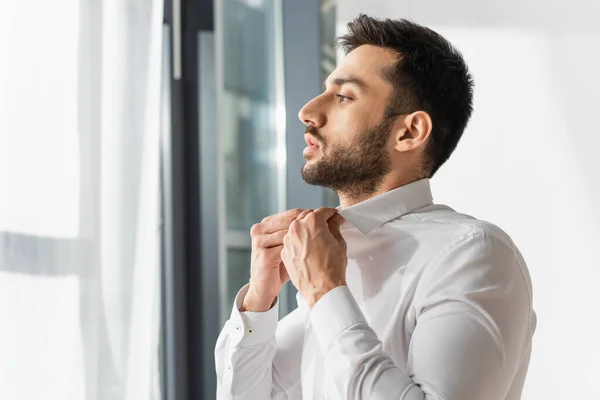 Vista lateral del hombre barbudo con camisa blanca en casa - foto de stock