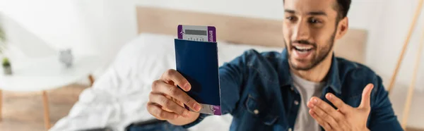 Passport with air ticket in hand of blurred man at home, banner — Stock Photo