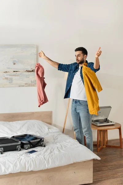 Tourist throwing clothes near suitcase in bedroom — Stock Photo