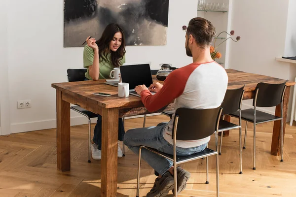 Couple de pigistes travaillant près des ordinateurs portables à la maison — Photo de stock