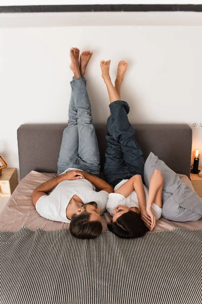 Smiling couple looking at each other on bed — Stock Photo