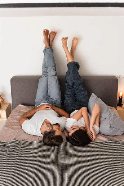 Lächelndes Paar, das sich auf dem Bett anschaut — Stockfoto