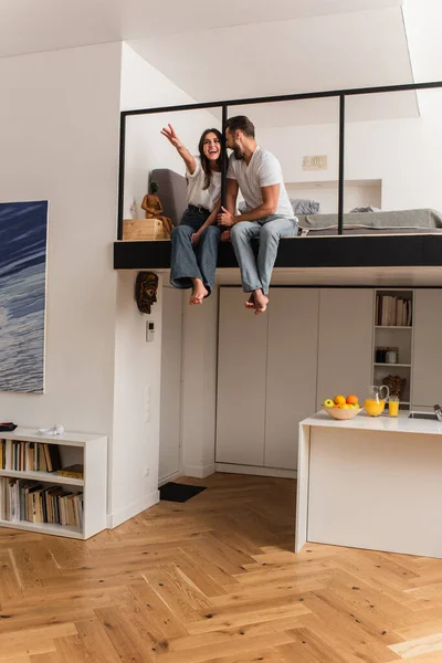 Mujer feliz tirando de la mano cerca de novio en casa - foto de stock