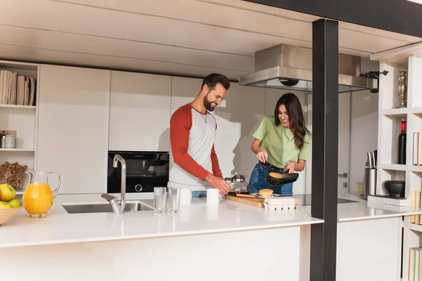 Coppia sorridente che prepara la colazione vicino al caffè in cucina — Foto stock