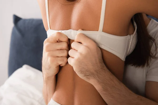 Cropped view of man unfastening bra of seductive woman — Stock Photo