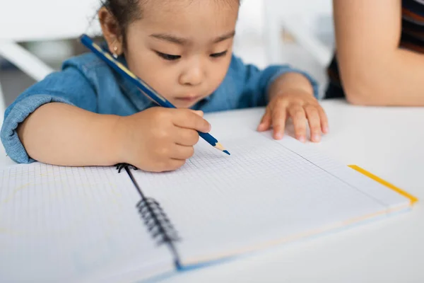 Floue asiatique tout-petit fille dessin avec couleur crayon — Photo de stock