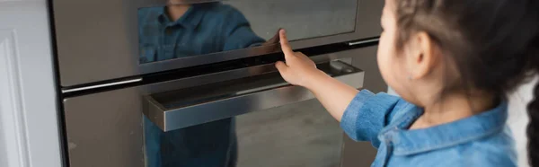 Ragazzo asiatico in primo piano sfocato che tocca l'esposizione del forno a casa, banner — Foto stock