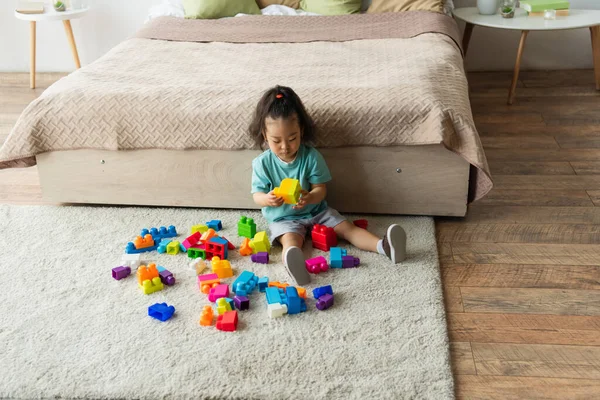 Asiatisches Kleinkind spielt Bausteine im Schlafzimmer — Stockfoto