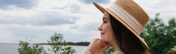 Felice giovane donna in cappello di paglia vicino al mare, striscione — Foto stock