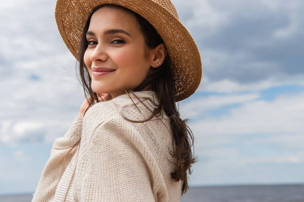 Compiaciuto giovane donna in cappello da sole contro il cielo blu — Foto stock