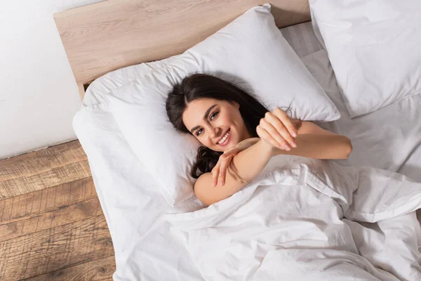 Vista superior da mulher sorridente deitada na cama — Fotografia de Stock