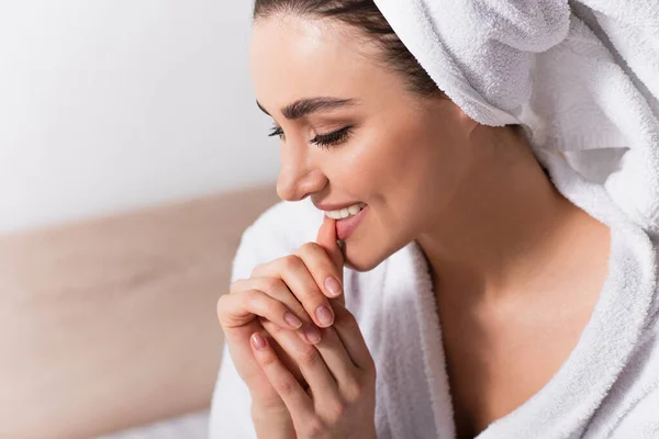 Mujer feliz en toalla en la cabeza clavo mordedor - foto de stock