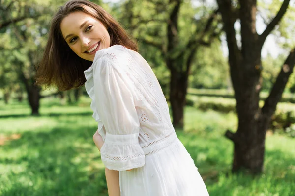Pretty woman in summer dress smiling in park — Stock Photo