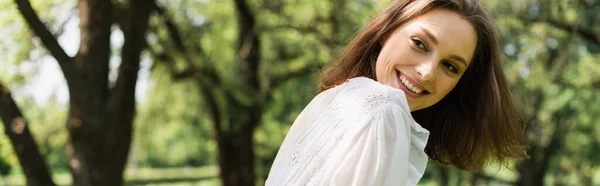 Mujer sonriente en vestido blanco en el parque de verano, pancarta - foto de stock
