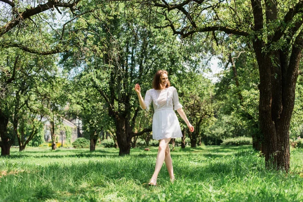 Красива жінка в літній сукні, що йде в парку — стокове фото