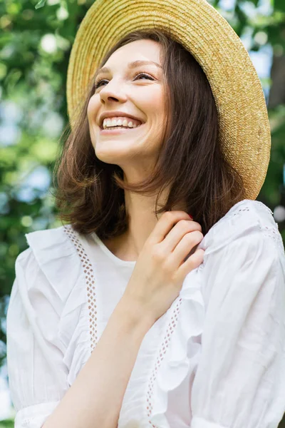 Femme gaie en robe blanche et chapeau de soleil à l'extérieur — Photo de stock