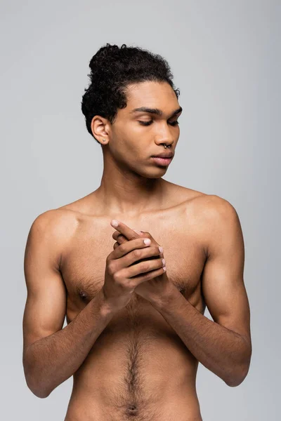 Sin camisa, hombre afroamericano perforado de pie aislado en gris, concepto de belleza - foto de stock