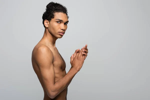 Homme afro-américain torse nu avec une peau parfaite regardant la caméra tout en se tenant isolé sur gris, concept de beauté — Photo de stock