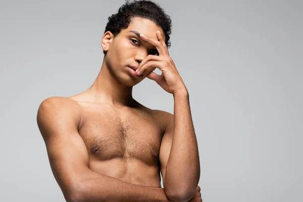 Hombre afroamericano sin camisa posando con la mano cerca de la cara aislado en gris, concepto de belleza - foto de stock