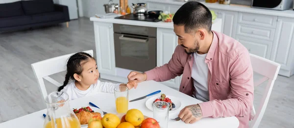 Asiático pai de mãos dadas com criança filha durante o café da manhã, banner — Fotografia de Stock