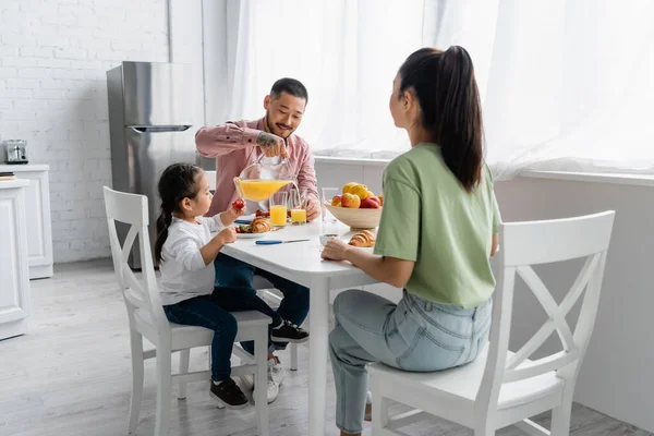 Feliz asiático familia teniendo desayuno en cocina - foto de stock