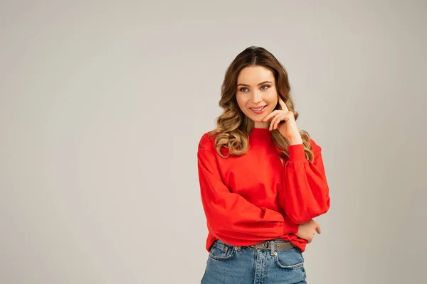 Femme gaie en sweat-shirt regardant loin isolé sur gris — Photo de stock