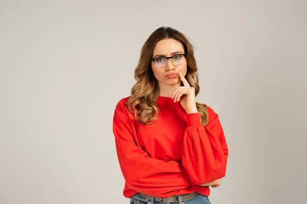 Femme coûteuse dans les lunettes boudant lèvres isolées sur gris — Photo de stock