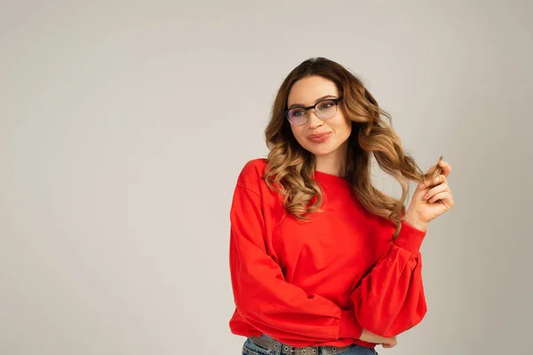 Zufriedene Frau in Sweatshirt und Brille isoliert auf grau — Stockfoto