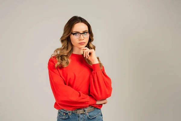 Nachdenkliche Frau mit Brille blickt vereinzelt auf graue Kamera — Stockfoto