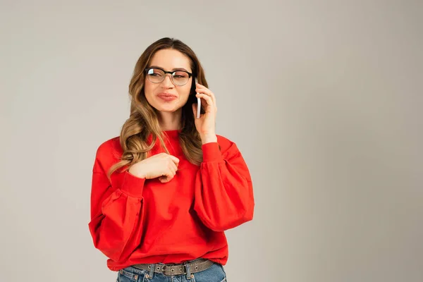 Piacere donna in occhiali parlare su smartphone isolato su grigio — Foto stock