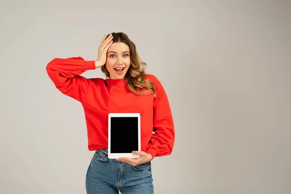 Mulher animado segurando tablet digital com tela em branco isolado em cinza — Fotografia de Stock