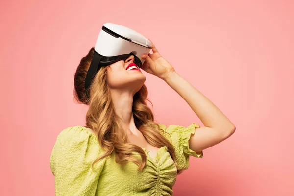 Smiling woman in vr headset looking up isolated on pink — Stock Photo