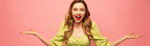 Mulher alegre com as mãos estendidas e boca aberta isolada em rosa, banner — Stock Photo