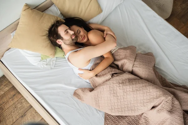 Vue supérieure de l'homme étreignant petite amie au lit — Photo de stock