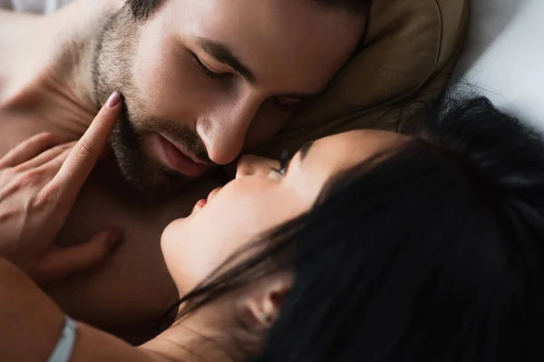 Close up of seductive woman and shirtless man hugging at home — Stock Photo