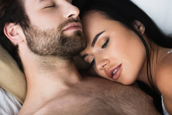 Giovane donna sdraiata sul petto del fidanzato senza maglietta — Foto stock