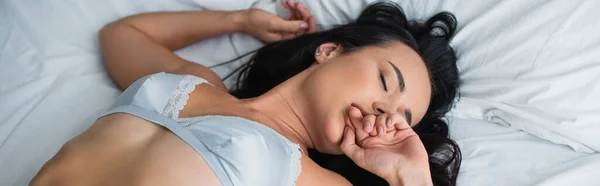 Hochwinkelaufnahme einer jungen Frau in sexy Dessous, die sich auf dem Bett wohl fühlt, Banner — Stockfoto