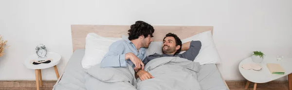 Гей пара лежит на кровати утром, баннер — стоковое фото