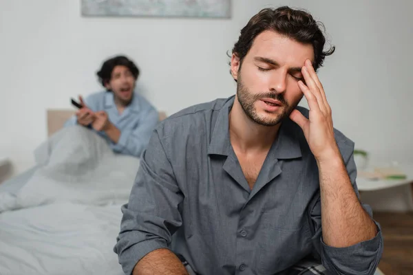 Man suffering from headache while quarrelling with boyfriend — Stock Photo