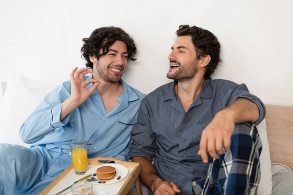 Alegre gay homem comer mirtilo perto namorado — Fotografia de Stock