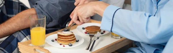 Cropped view of gay couple having breakfast in bed, banner — Stock Photo