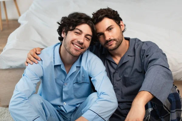Fröhliche junge schwule Paare umarmen sich im Schlafzimmer — Stockfoto