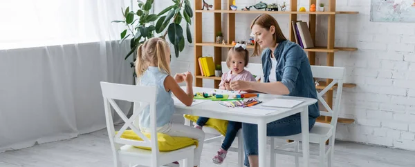 Kindergarten teacher molding plasticine with disabled kid and preschooler girl, banner — Stock Photo