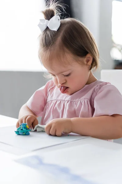 Bambino disabile con sindrome di Down stampaggio plastilina su carta — Foto stock