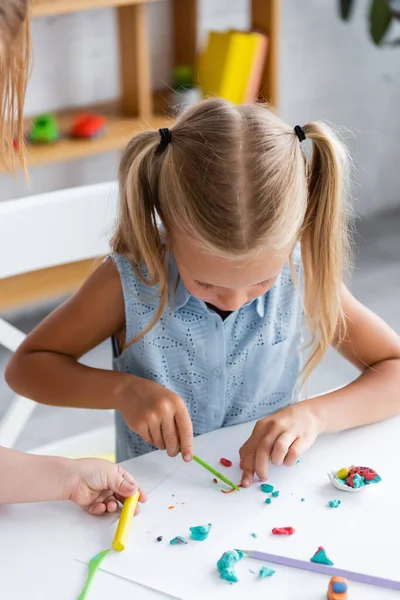 Blonde preschooler girl molding molding plasticine in private kindergarten — Stock Photo