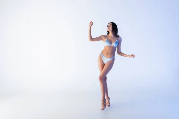 Piena lunghezza di giovane donna in lingerie di pizzo gesturing mentre posa sul blu — Foto stock