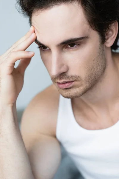 Young depressed man touching forehead in morning — Stock Photo