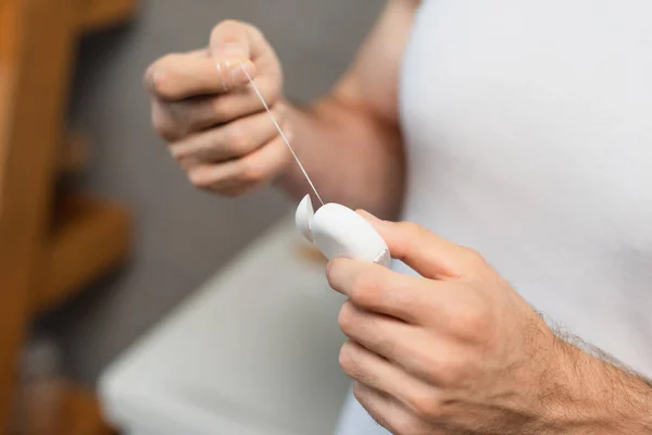 Selektiver Fokus der Zahnseide in den Händen des beschnittenen Mannes — Stockfoto